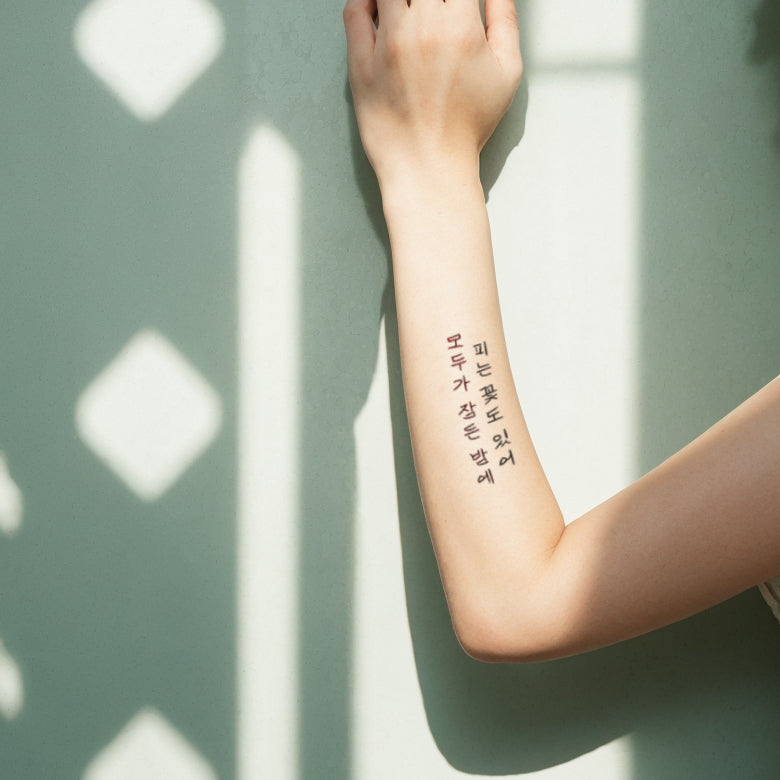 Arm with a Korean phrase temporary tattoo, displayed against a shadow-patterned wall, creating a serene and introspective mood.